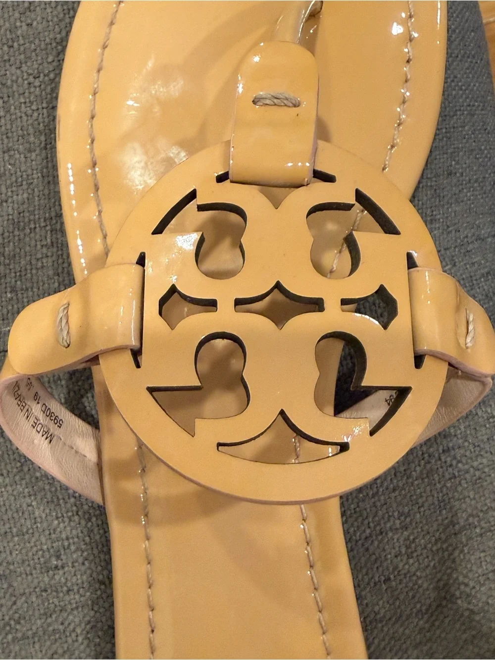 Tory Burch Patent Leather Thong Sandals  color is a pinky peach nude color.